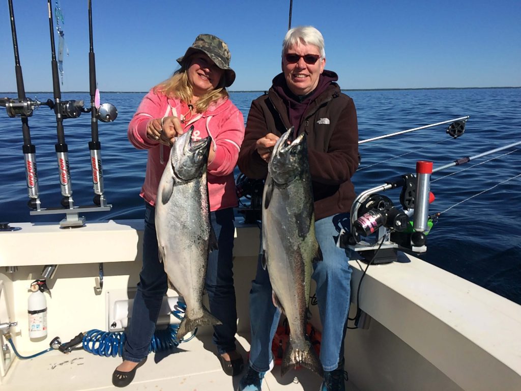 Woman and man holding large salmon, charter fishing, Lake Michigan, Sturgeon Bay Wisconsin