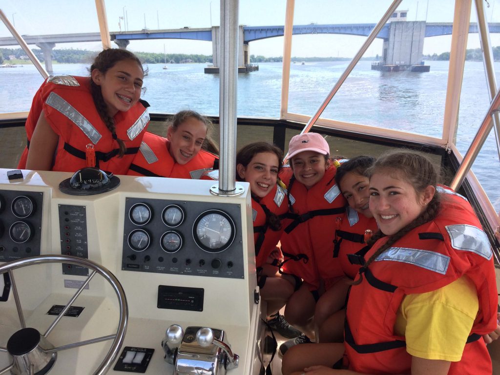 Group of girls wearing life vests on the top deck of charter fishing boat